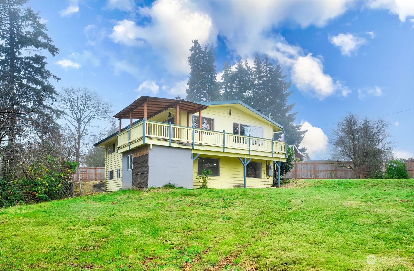 a view of a big house with a big yard and large trees