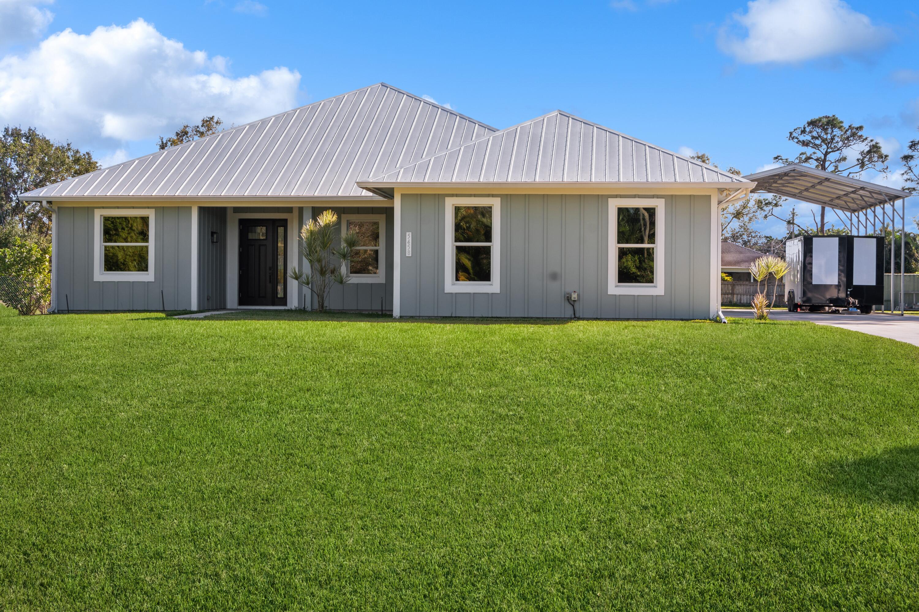 a front view of a house with a garden and yard