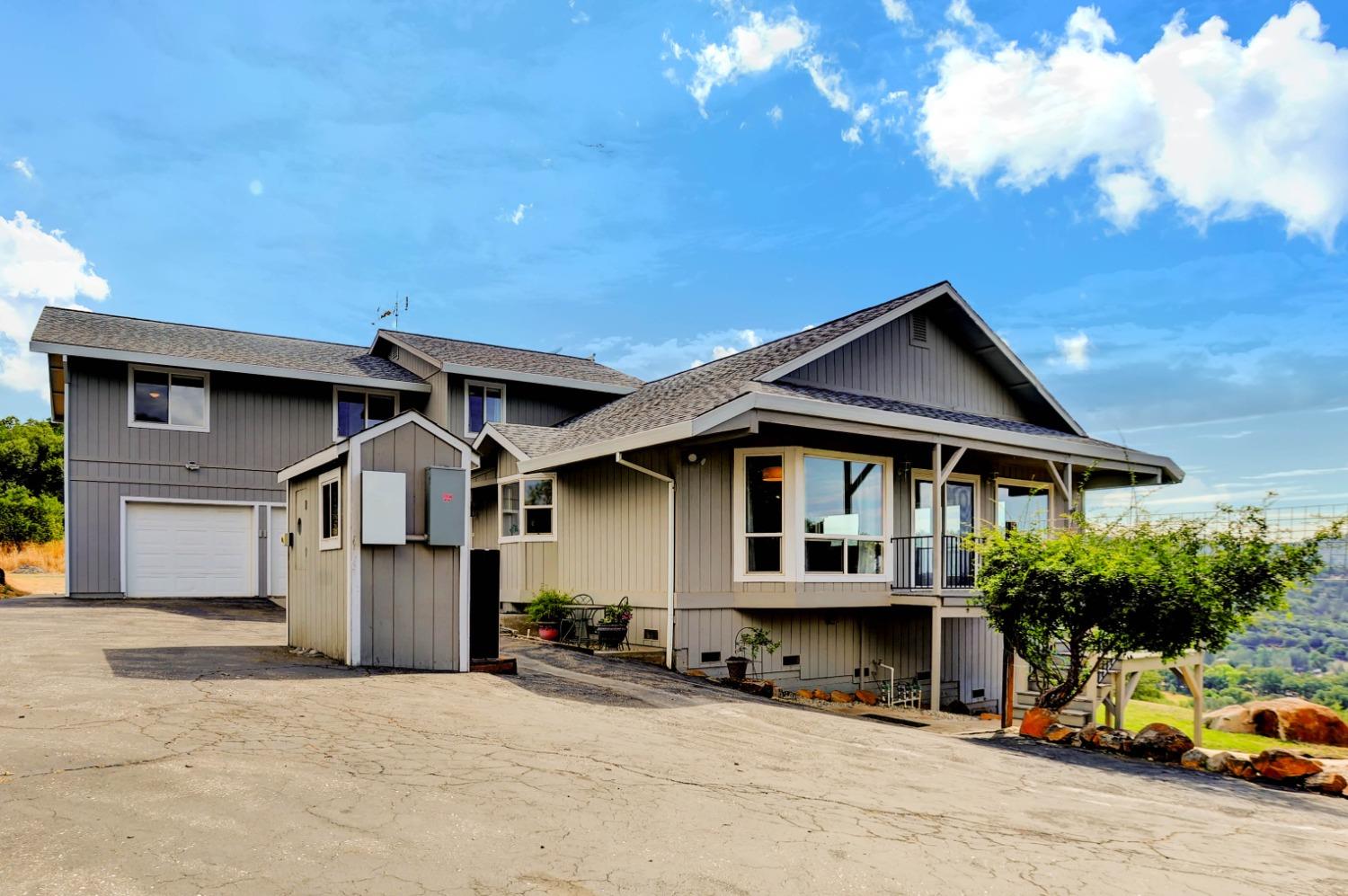 a front view of a house with a garden and car parked