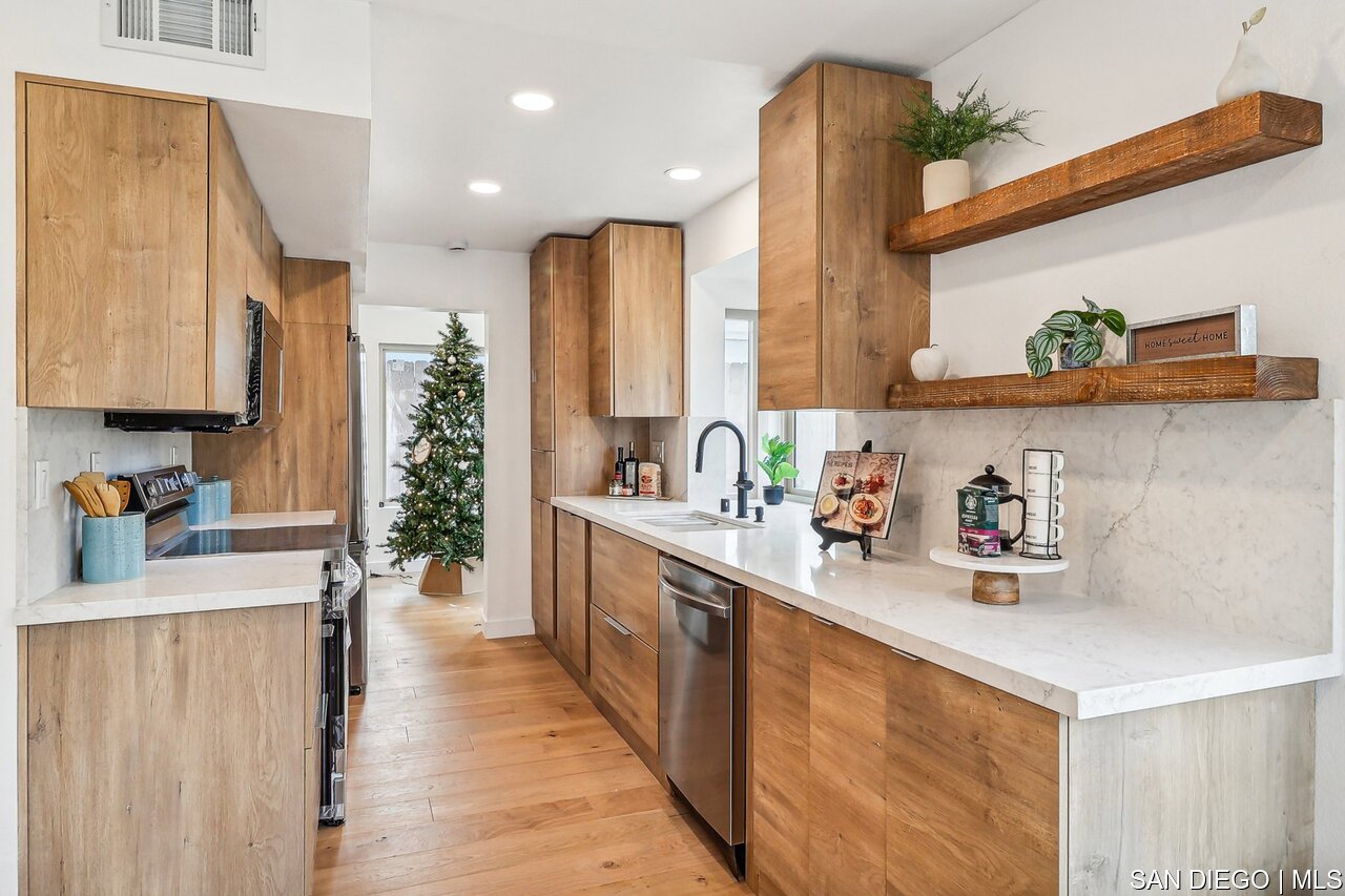 a kitchen with a refrigerator a sink and wooden cabinets