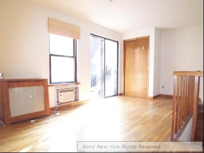 a view of a livingroom with wooden floor and a fireplace