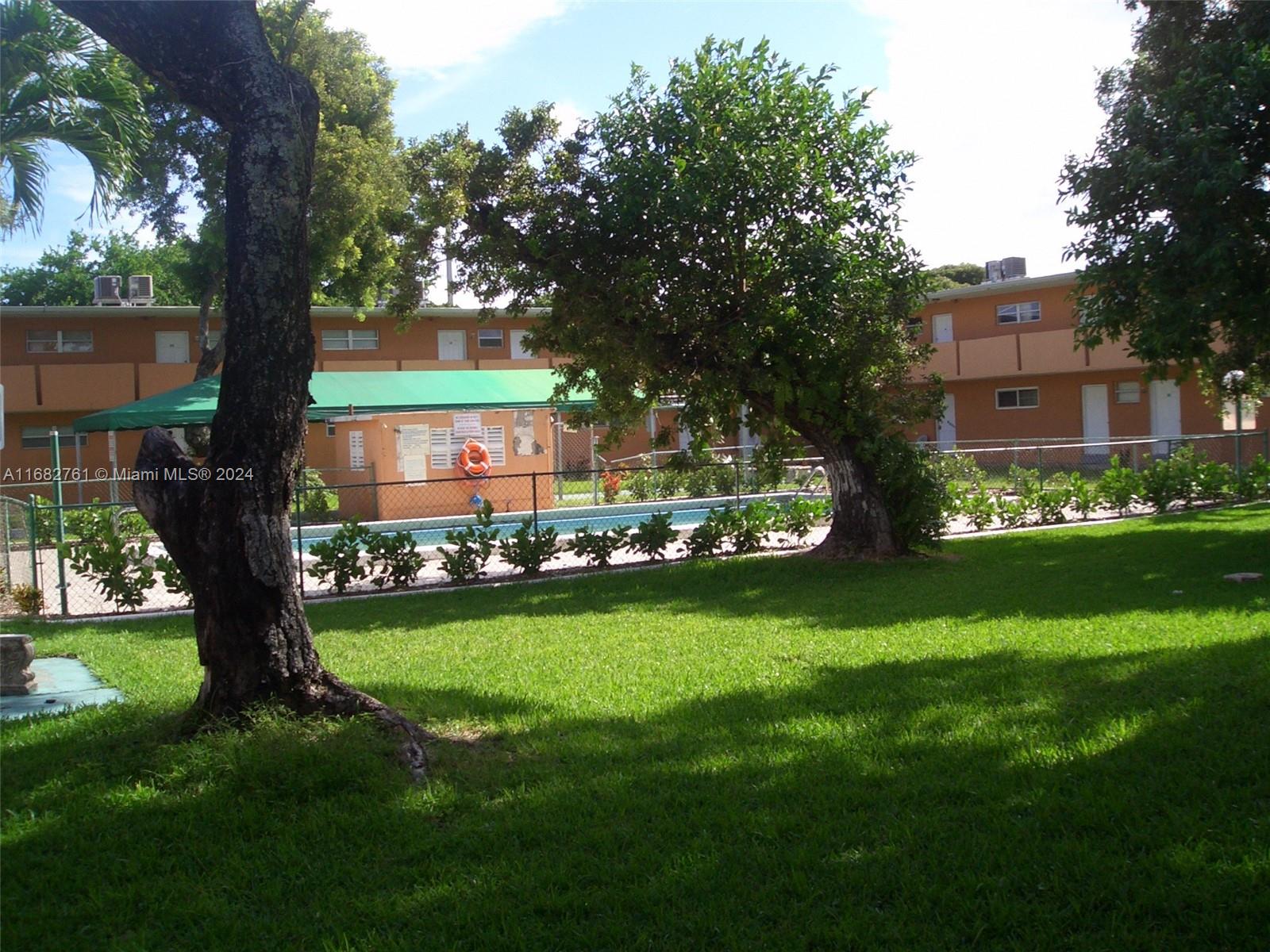 a front view of a house with a garden and trees