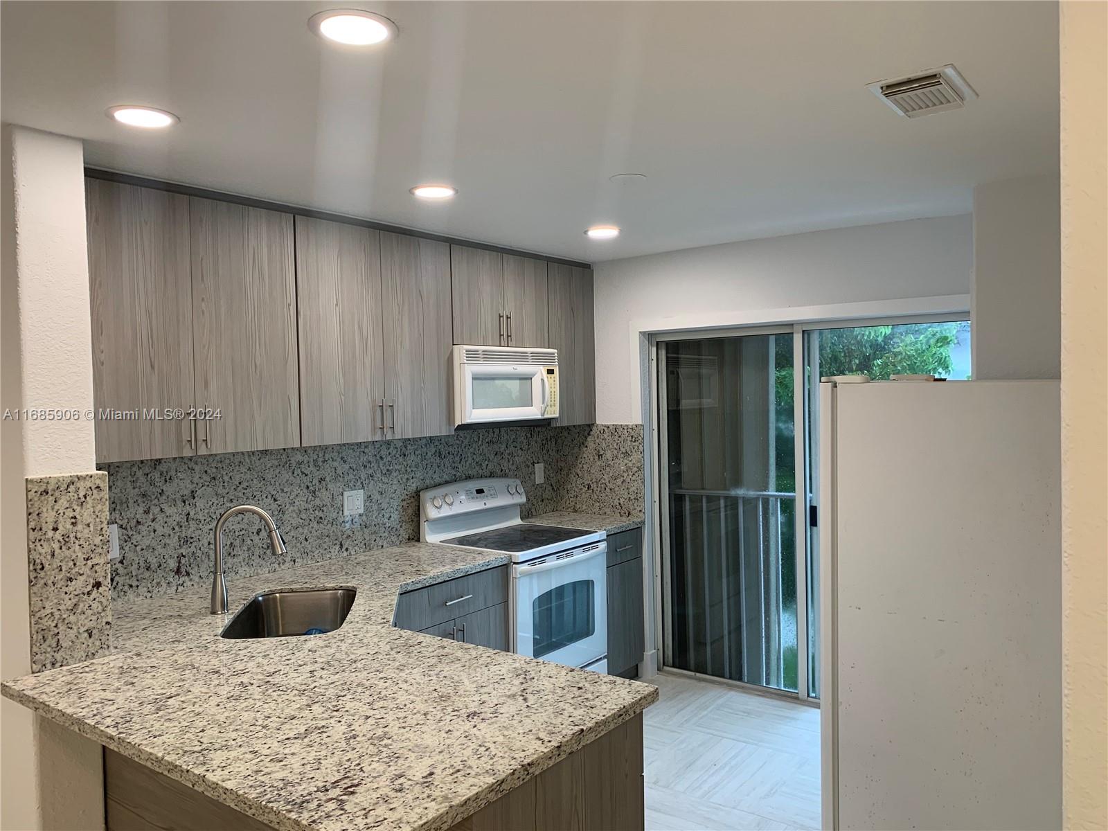 a kitchen with a refrigerator a sink and a cabinets