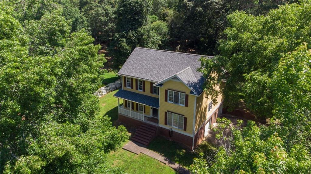 an aerial view of a house with balcony and trees al around