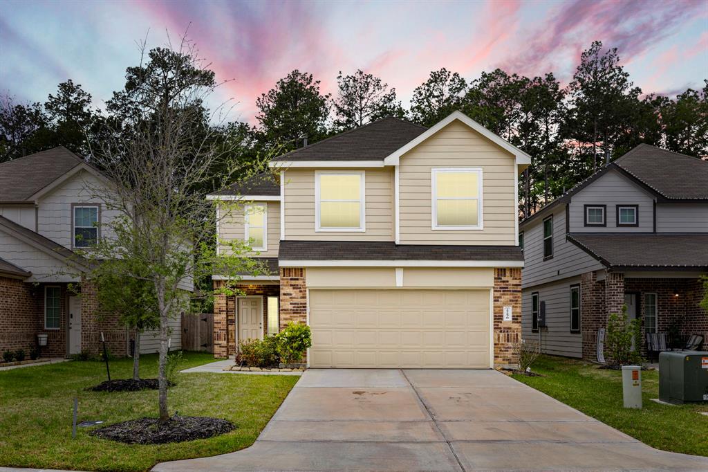 a front view of a house with a yard and trees