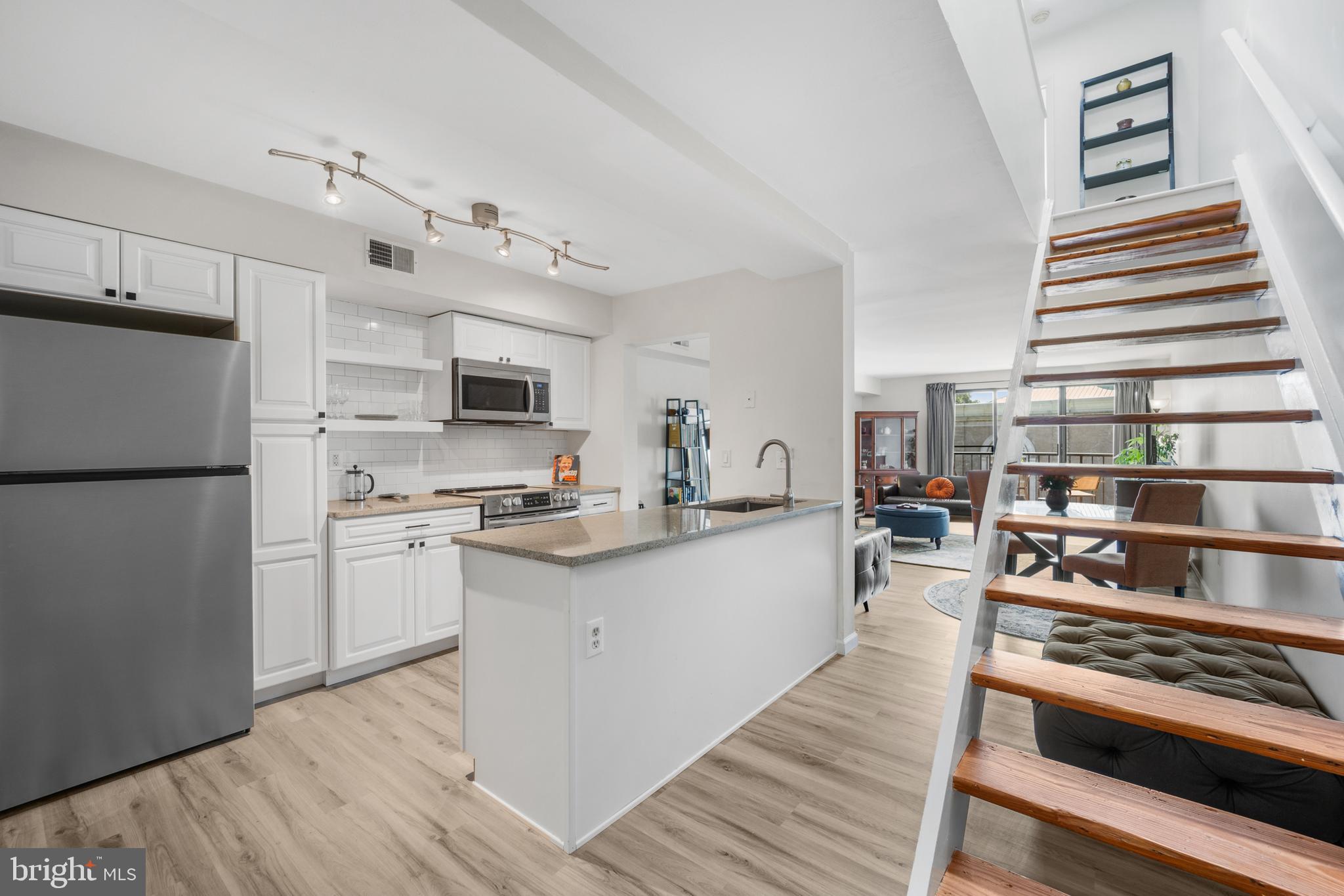 a kitchen with stainless steel appliances a stove a sink and a refrigerator