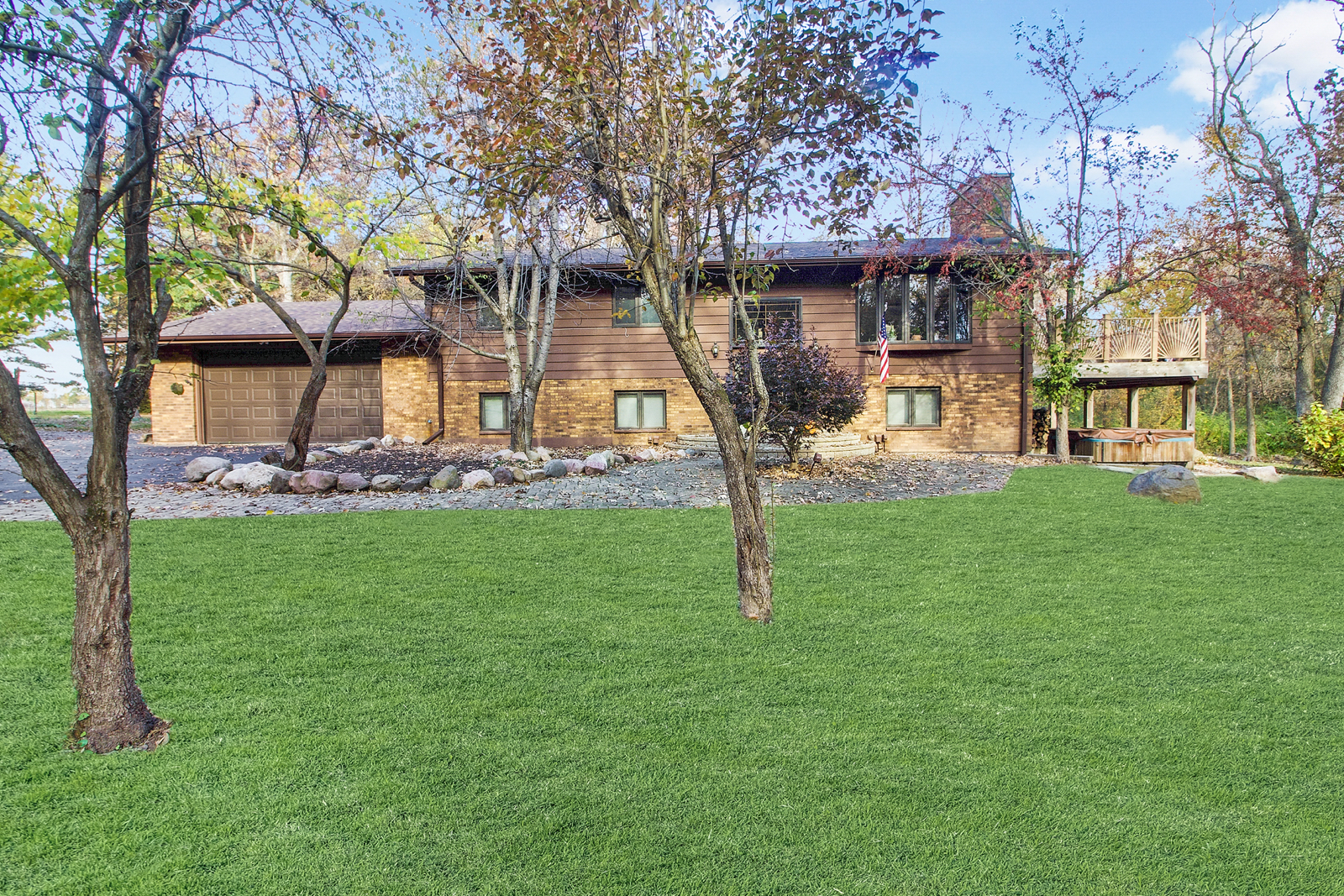 a front view of a house with a garden and tree