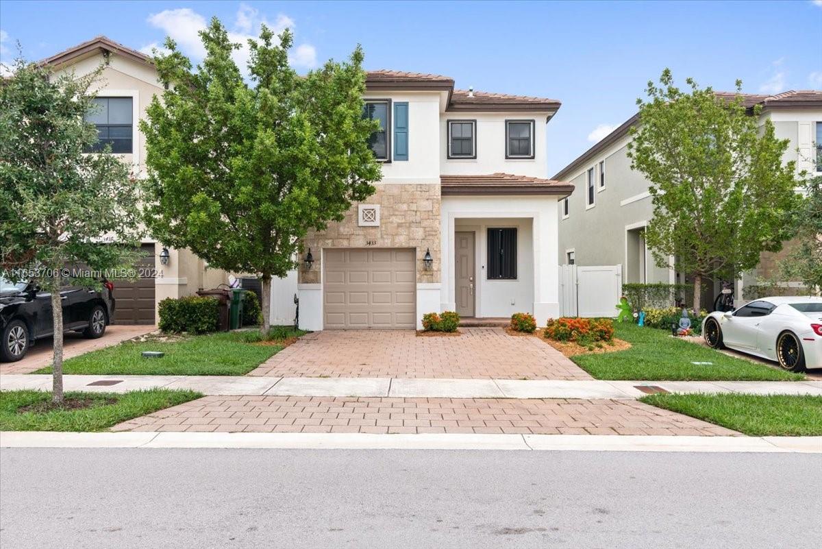 a front view of a house with a yard and garage