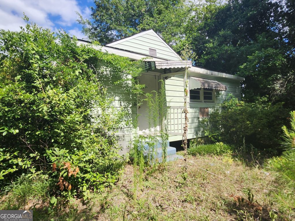 a front view of house with yard and trees around