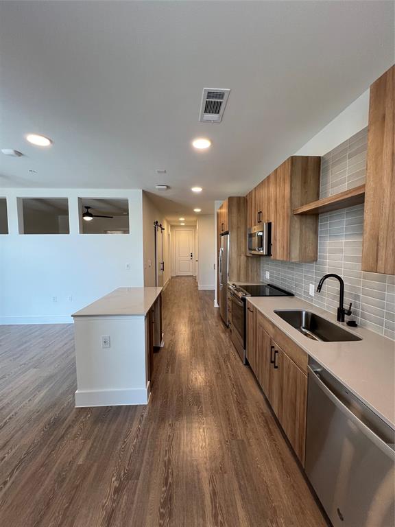 a kitchen with a sink and wooden floor