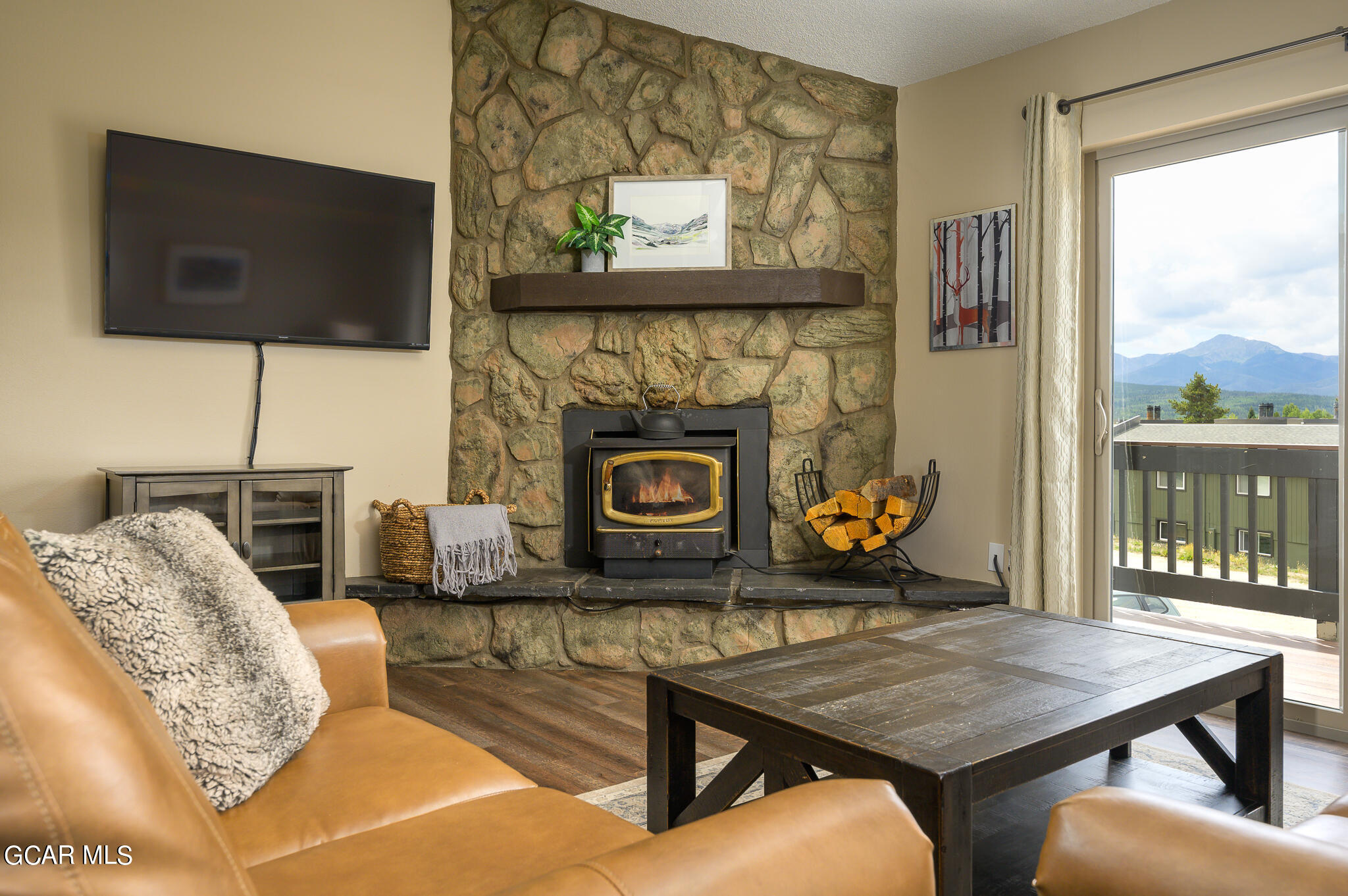 a living room with furniture a flat screen tv and a fireplace