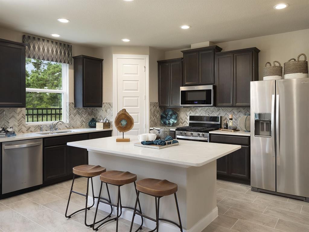 a kitchen with sink a microwave a refrigerator and cabinets