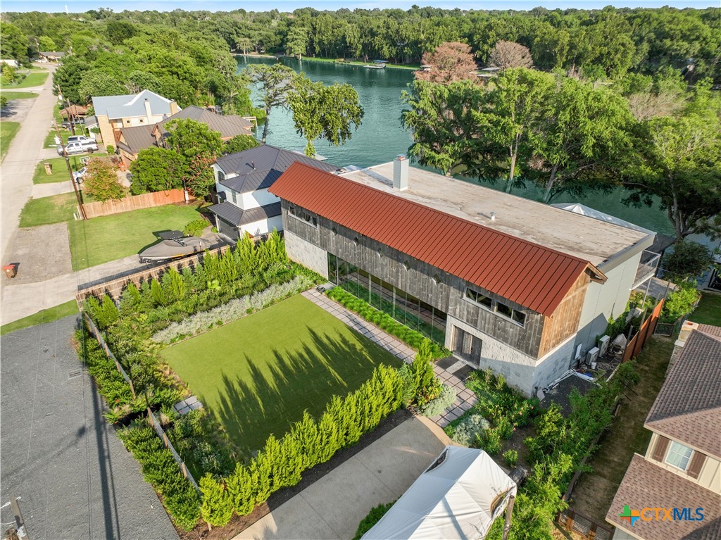 an aerial view of a house with a garden and lake view