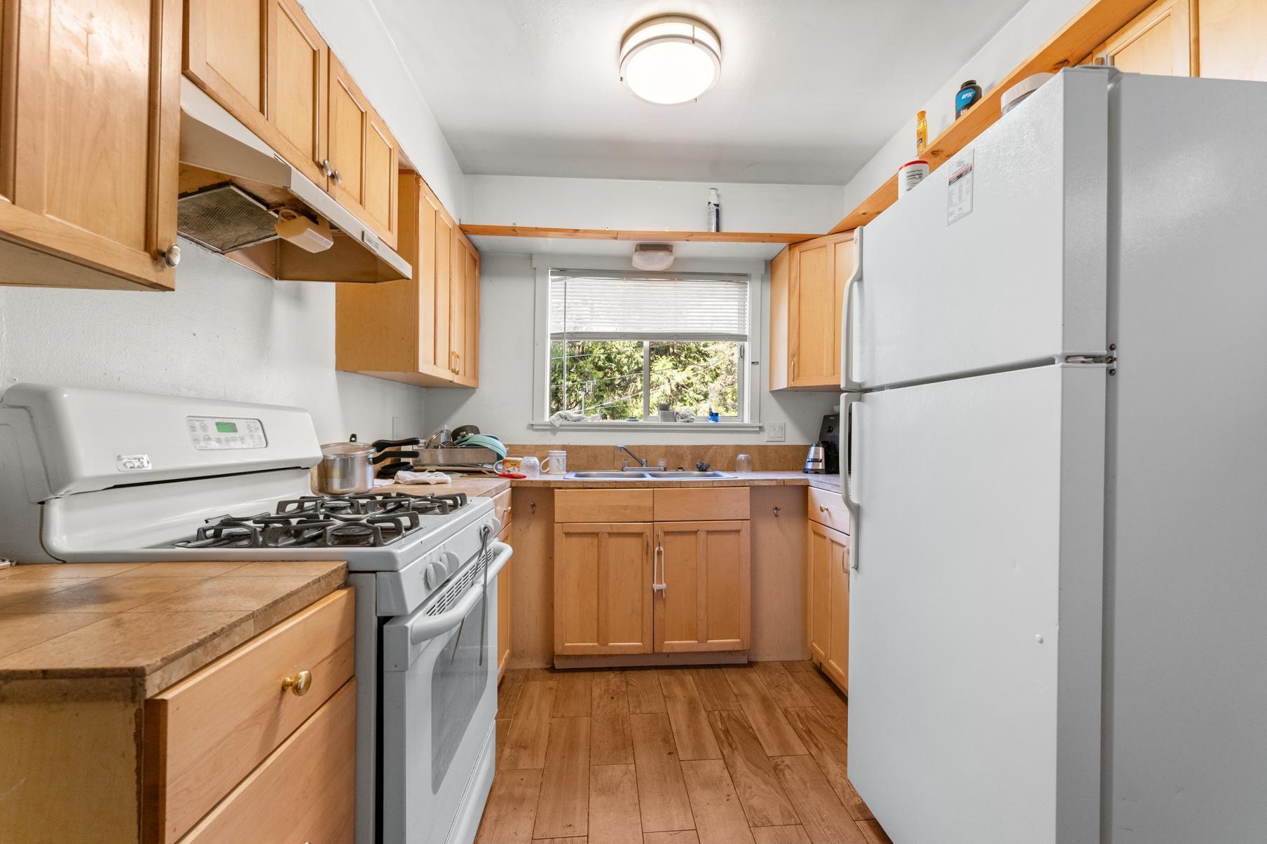 a kitchen with a refrigerator a stove a sink and a window