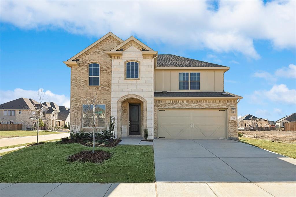 View of front of property with a garage and a front lawn