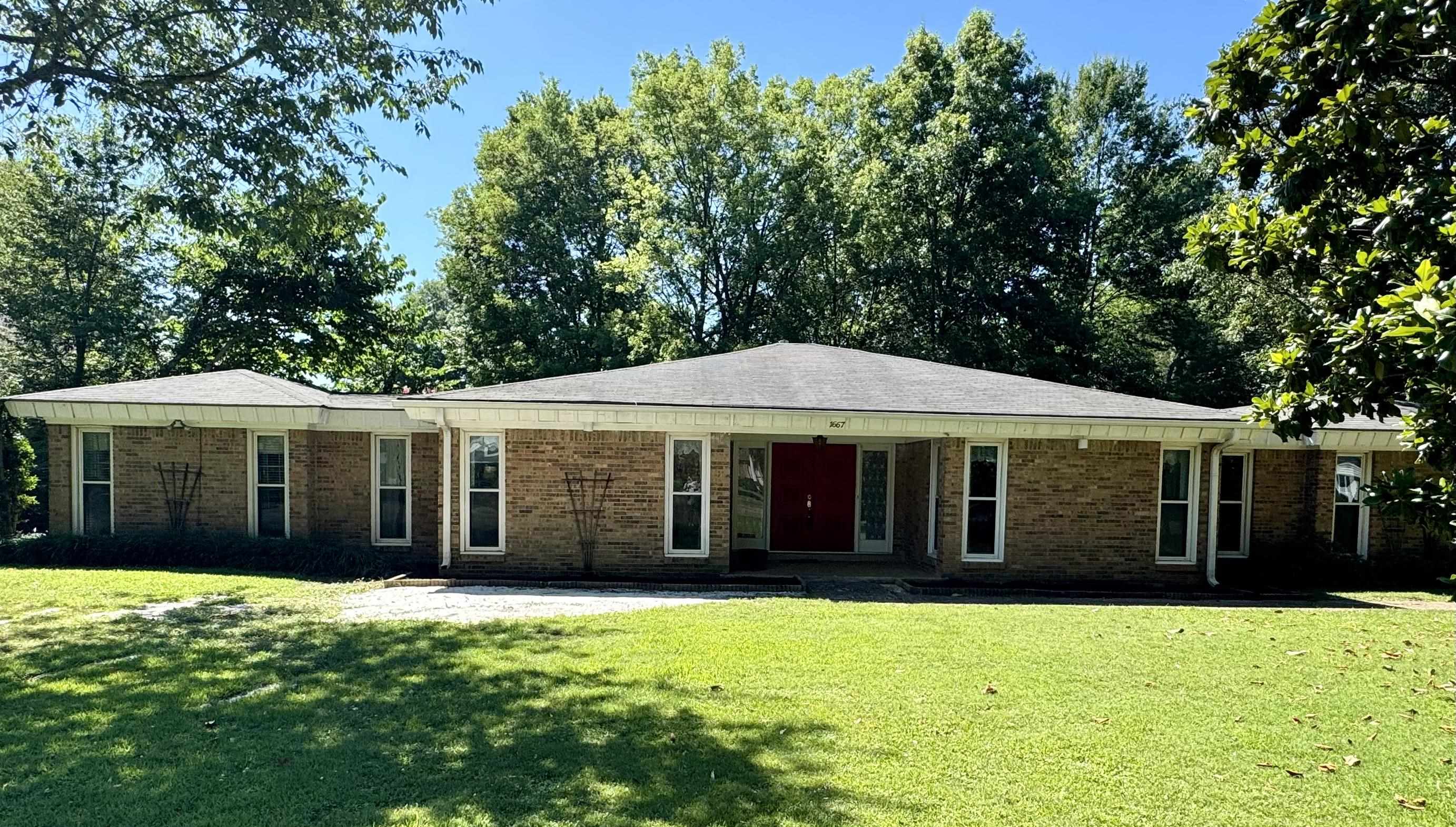 Single story home featuring a patio and a front lawn