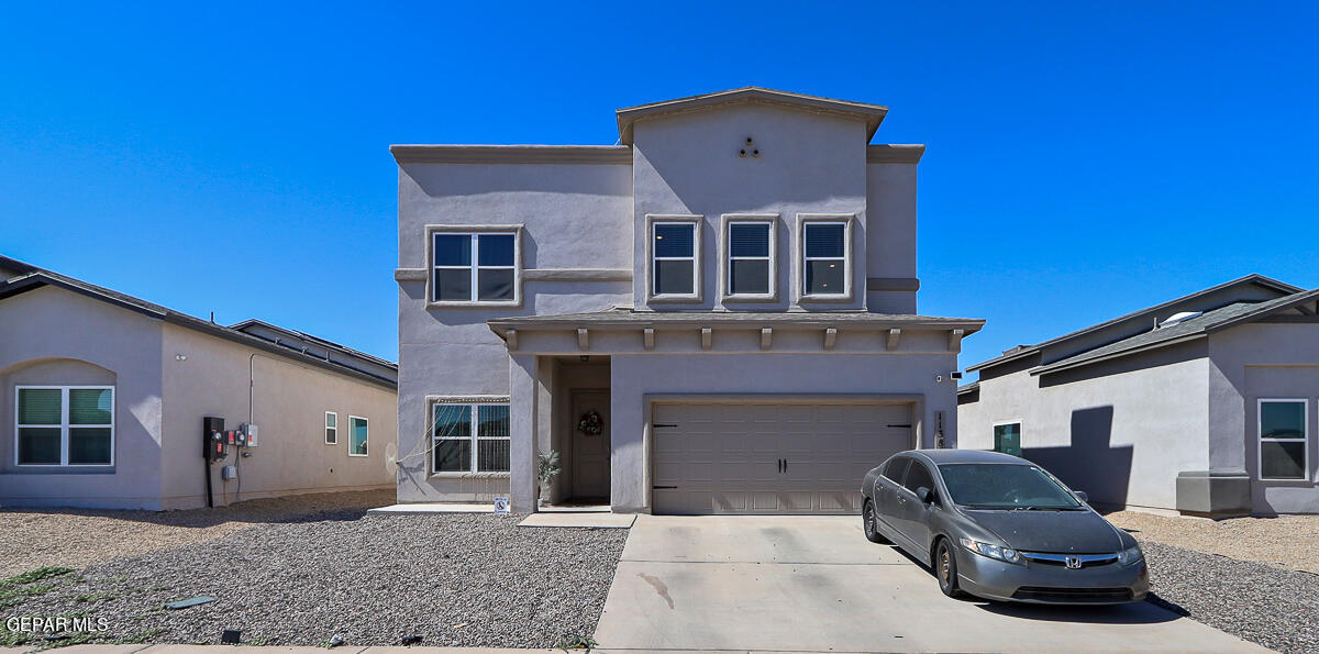 a front view of a house with yard and parking space