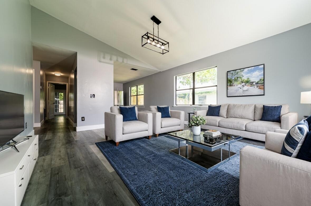 a living room with furniture wooden floor and a flat screen tv