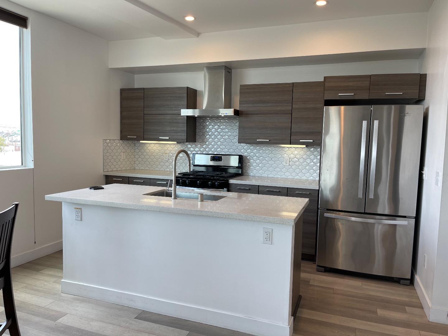 a kitchen with stainless steel appliances a refrigerator and a stove top oven