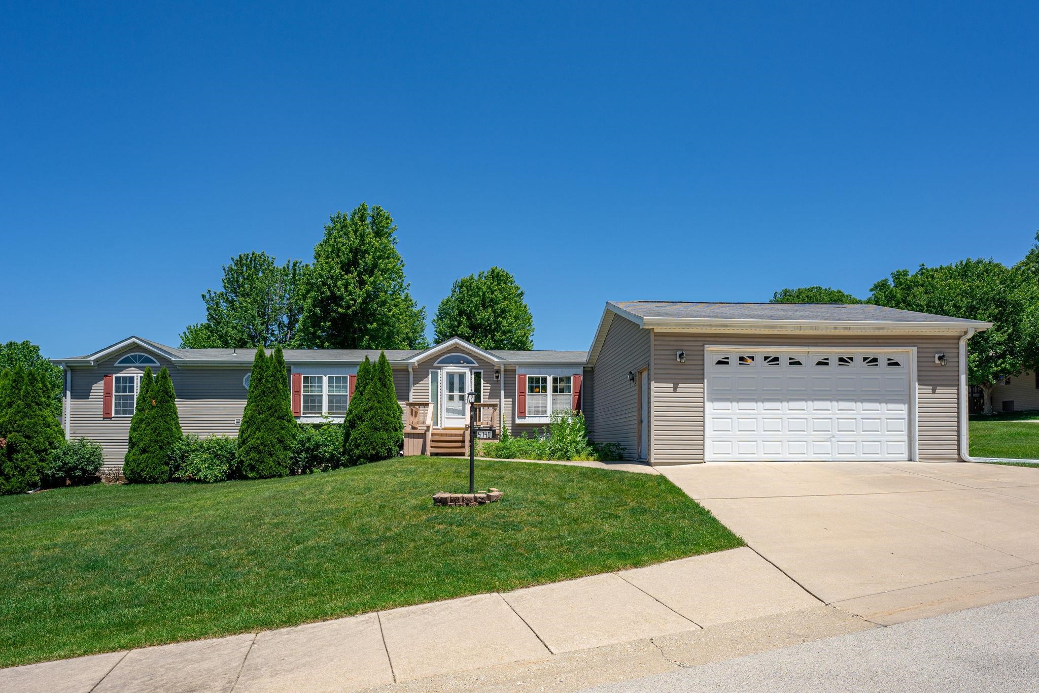 a front view of a house with a yard and trees