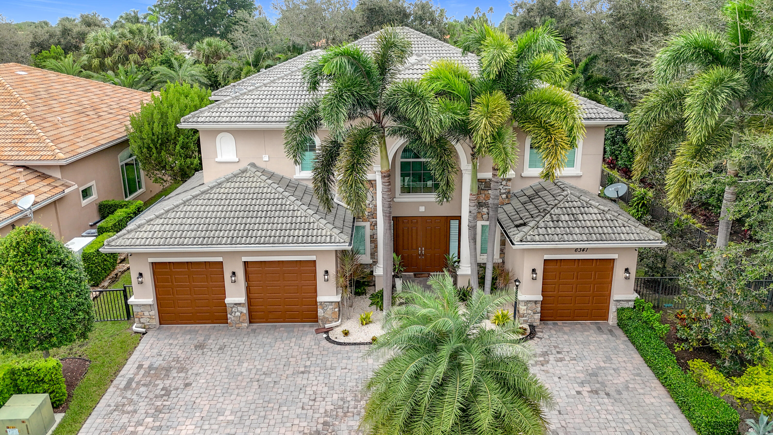 a front view of a house with a garden and trees