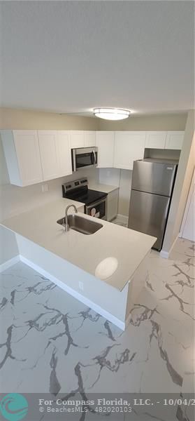 a bedroom with a bed and a view of kitchen