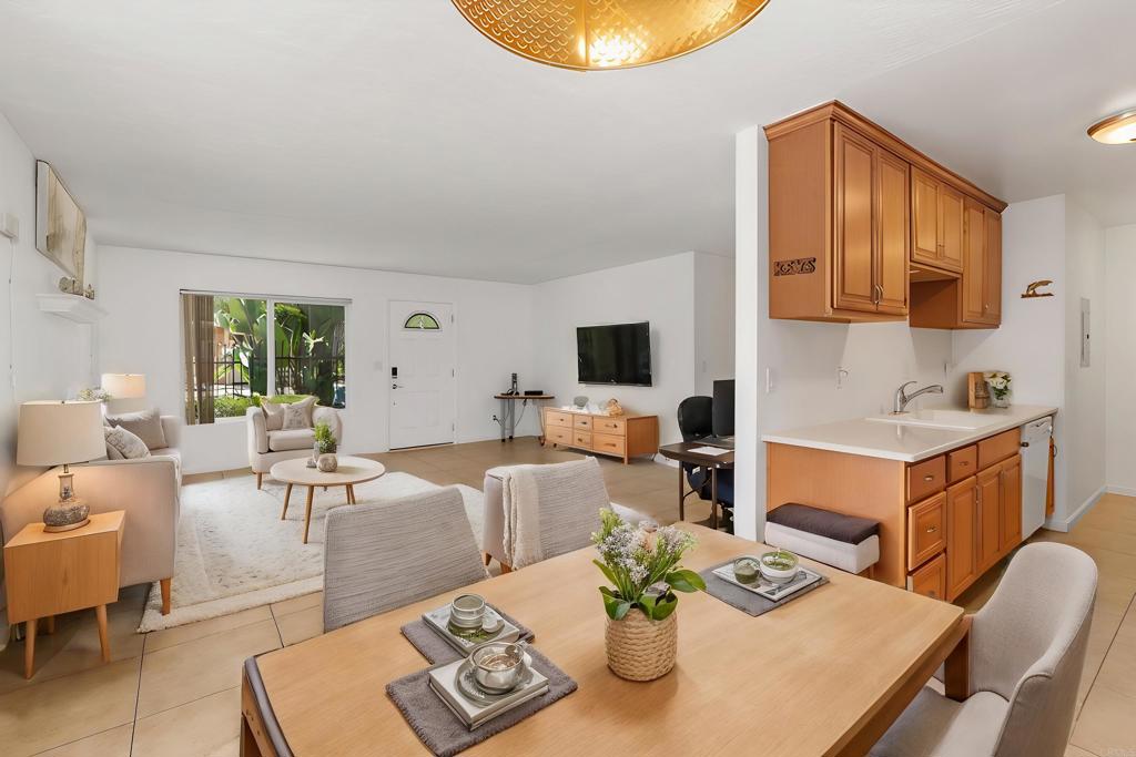 a living room with furniture a flat screen tv and kitchen view