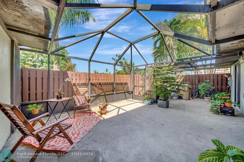 a view of a backyard with a table and chairs under an umbrella