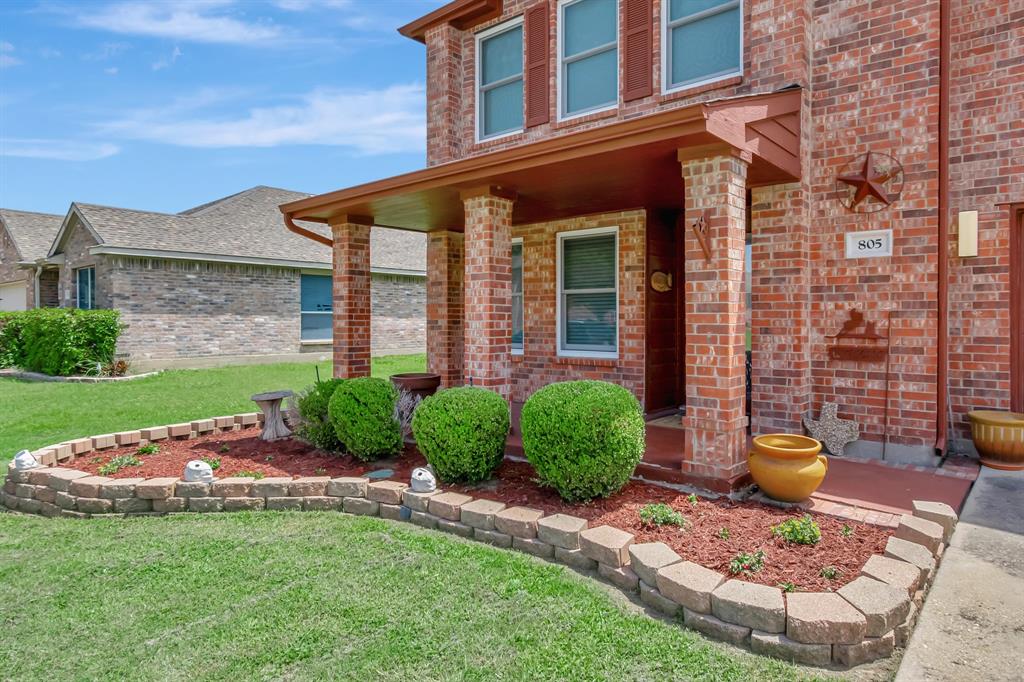 a front view of a house with a garden and outdoor seating