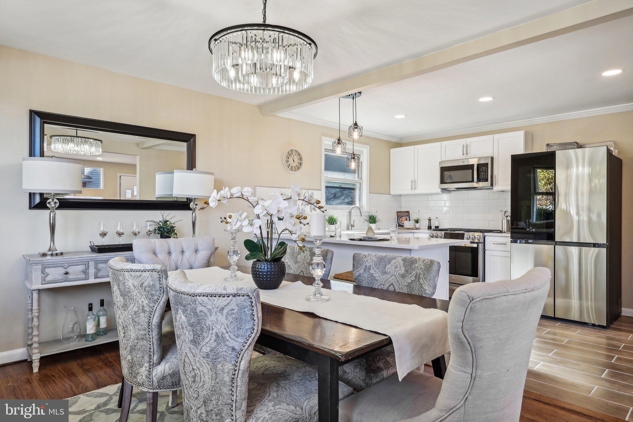 a dining room with furniture a kitchen and chandelier