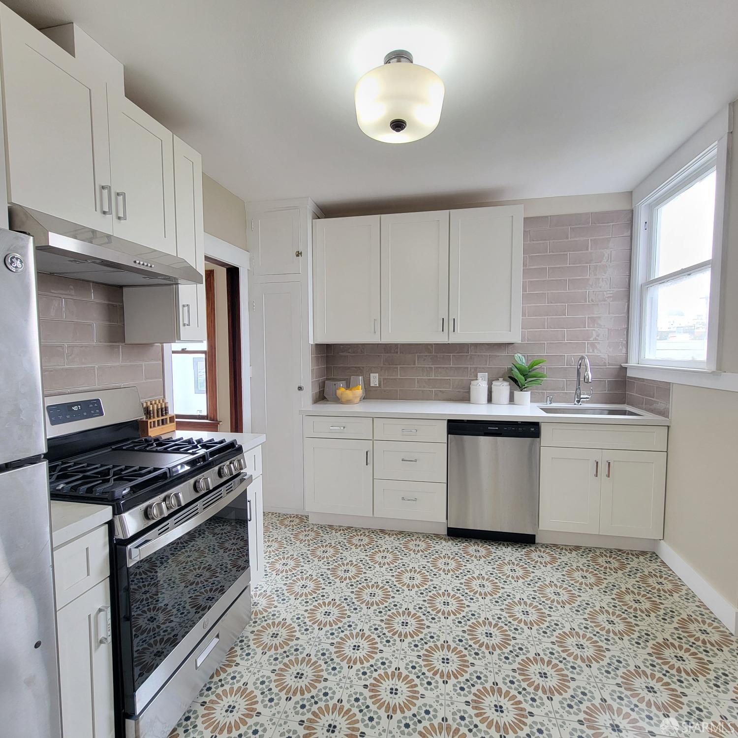 a kitchen with a stove a sink and cabinets