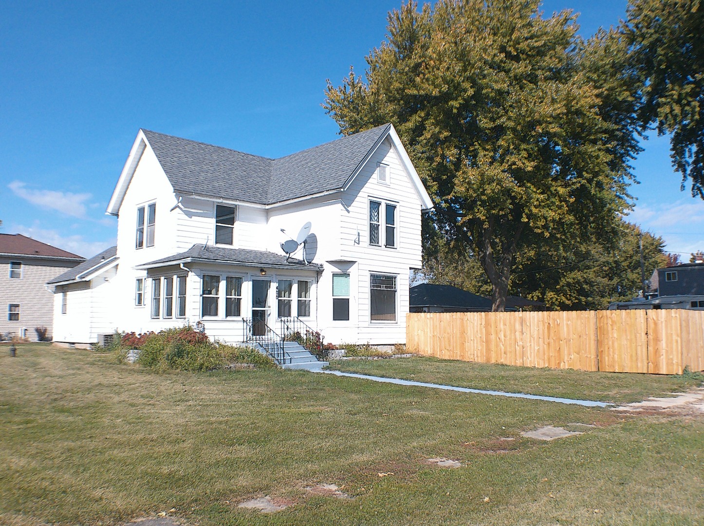 a front view of a house with a garden and lake view