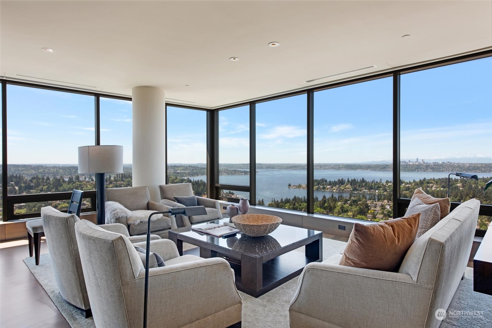 a living room with furniture water view and large windows