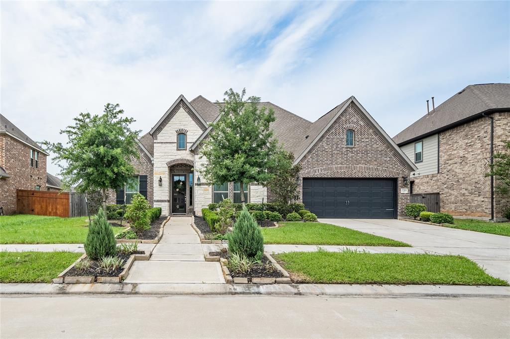 a front view of a house with a yard and garage