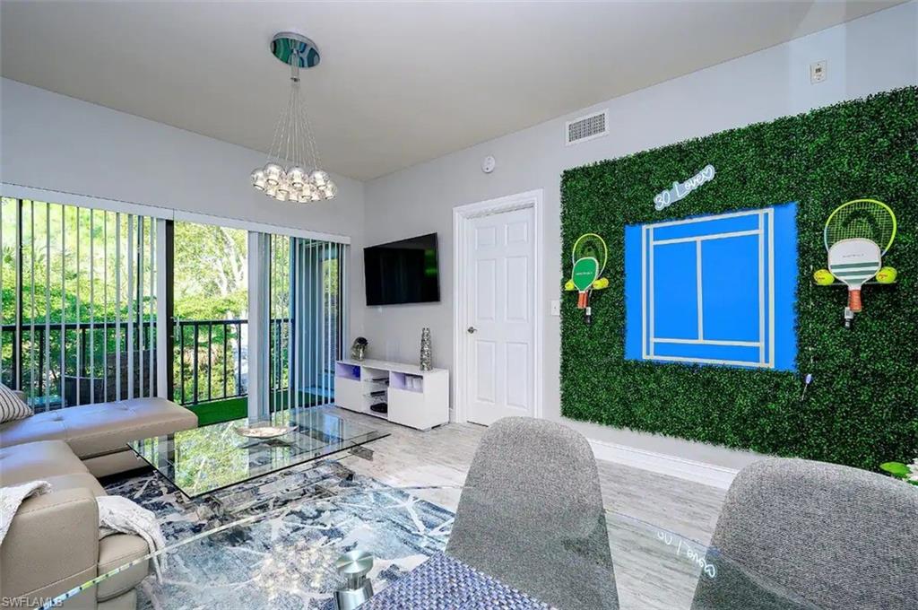 Living room with an inviting chandelier and hardwood / wood-style flooring