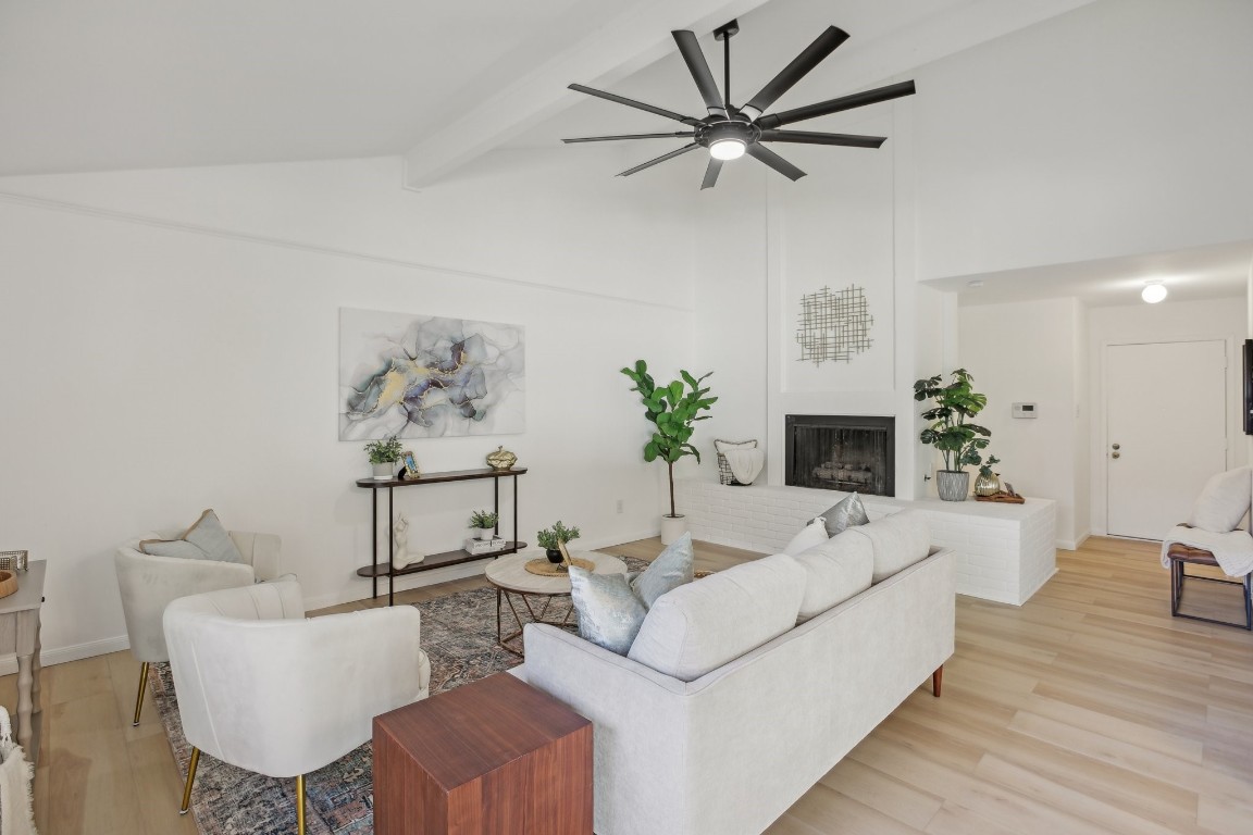 a living room with furniture a fireplace and a potted plant