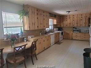 a kitchen with appliances cabinets and furniture