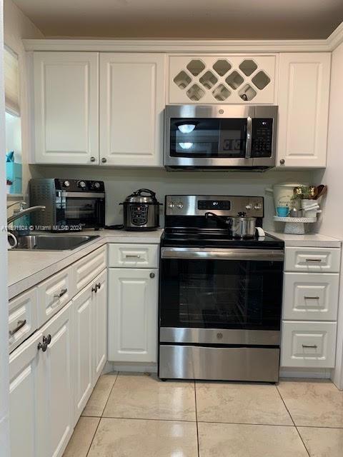 a kitchen with stainless steel appliances granite countertop white cabinets and black stove top oven with granite countertops