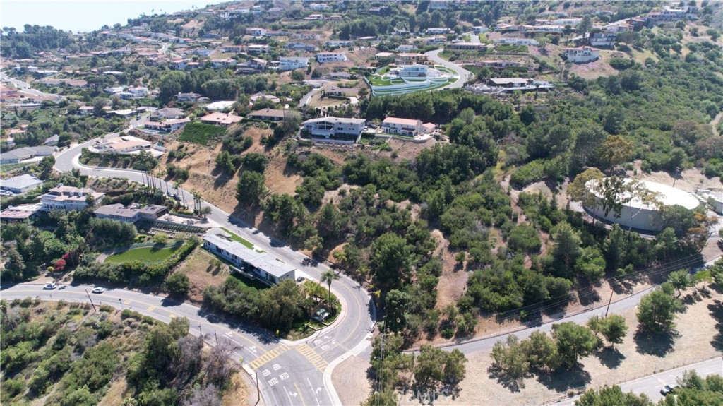 an aerial view of residential house with outdoor space and trees all around