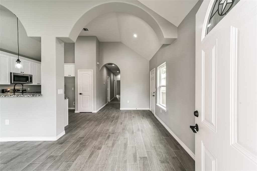 a view of a hallway with wooden floor and a living room