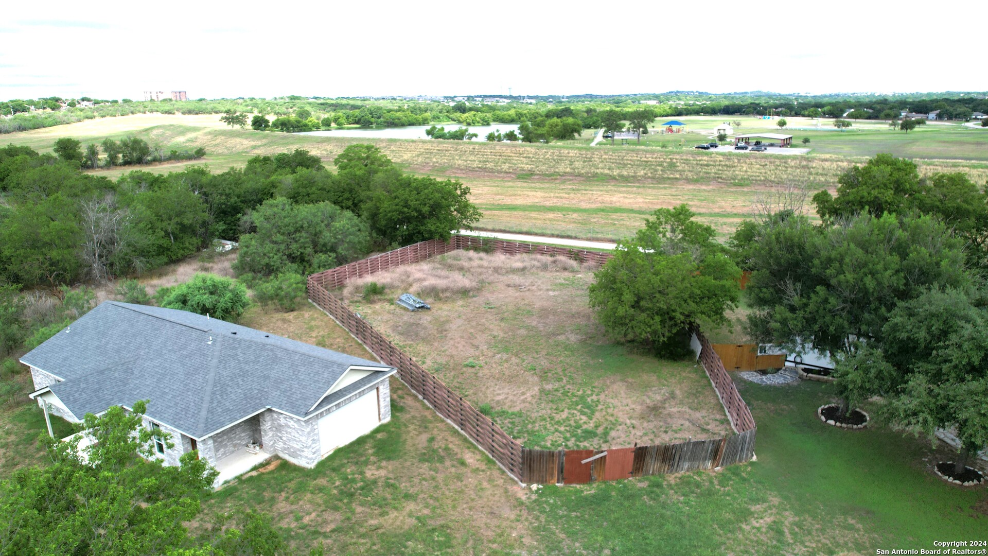 an aerial view of a house with a yard and lake view