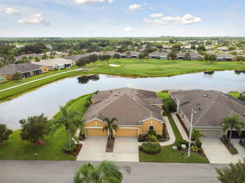 an aerial view of a house with a yard and lake view