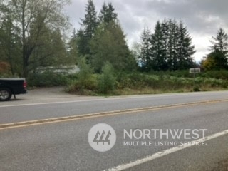 a view of a car parked on the side of the road with trees