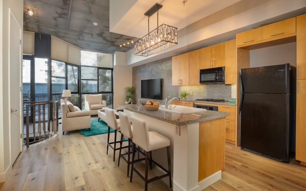 a kitchen with a table chairs refrigerator and a window