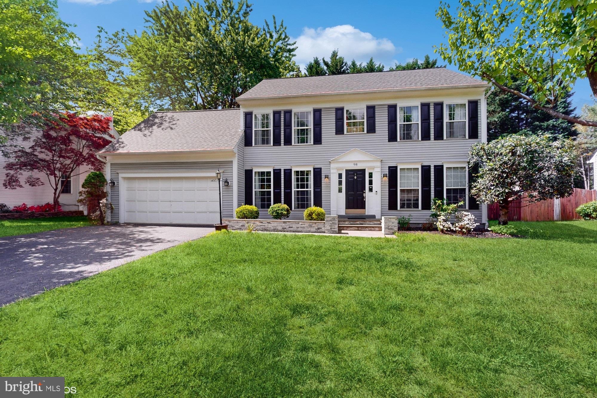 a front view of a house with a yard and green space