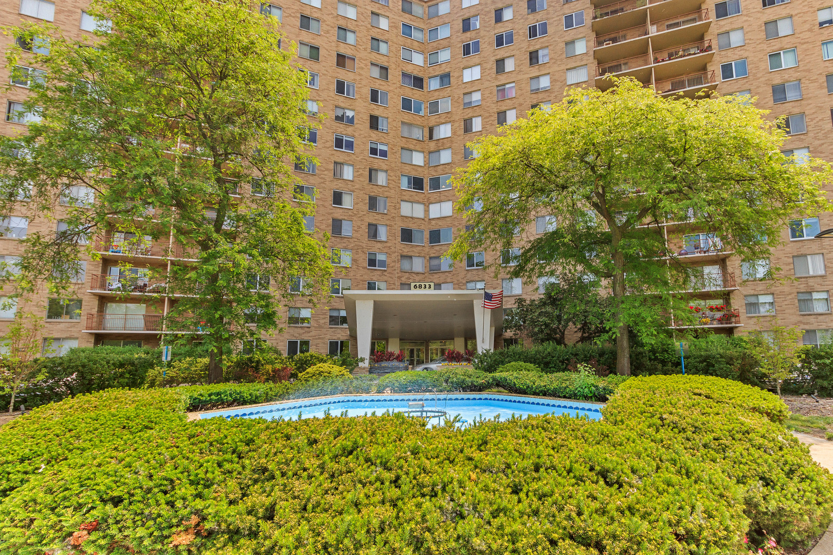 a view of a building with a garden and trees