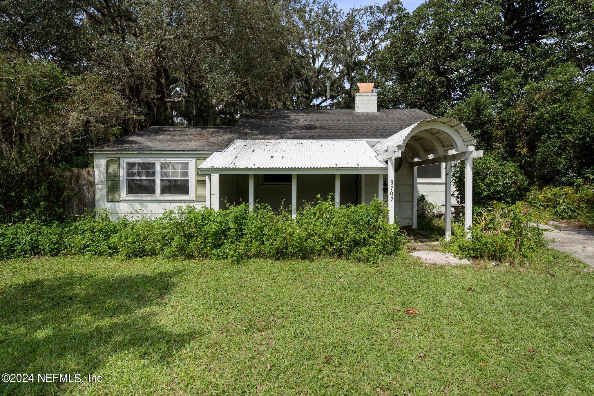 a front view of house with a garden