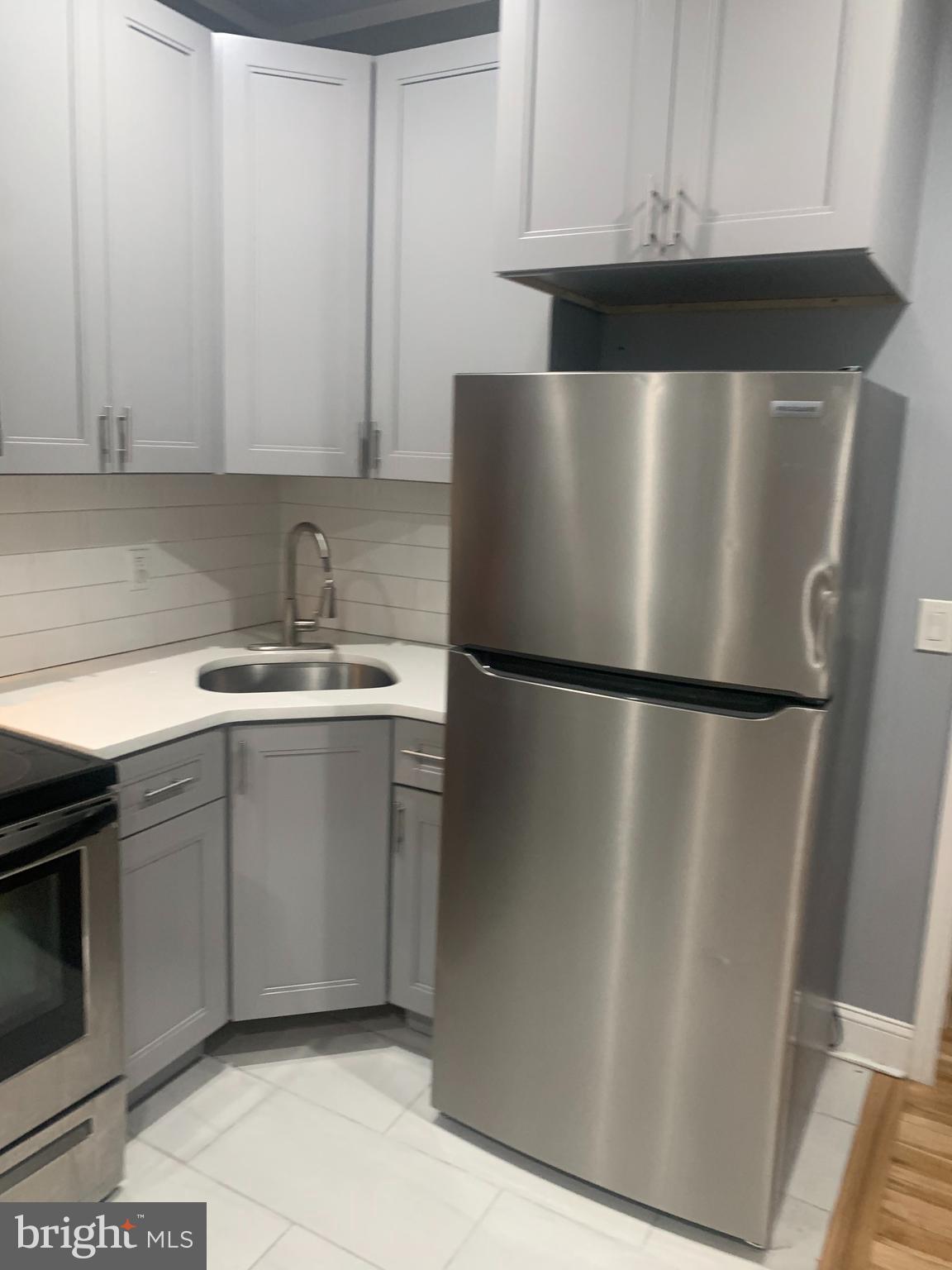 a kitchen with a refrigerator sink and cabinets