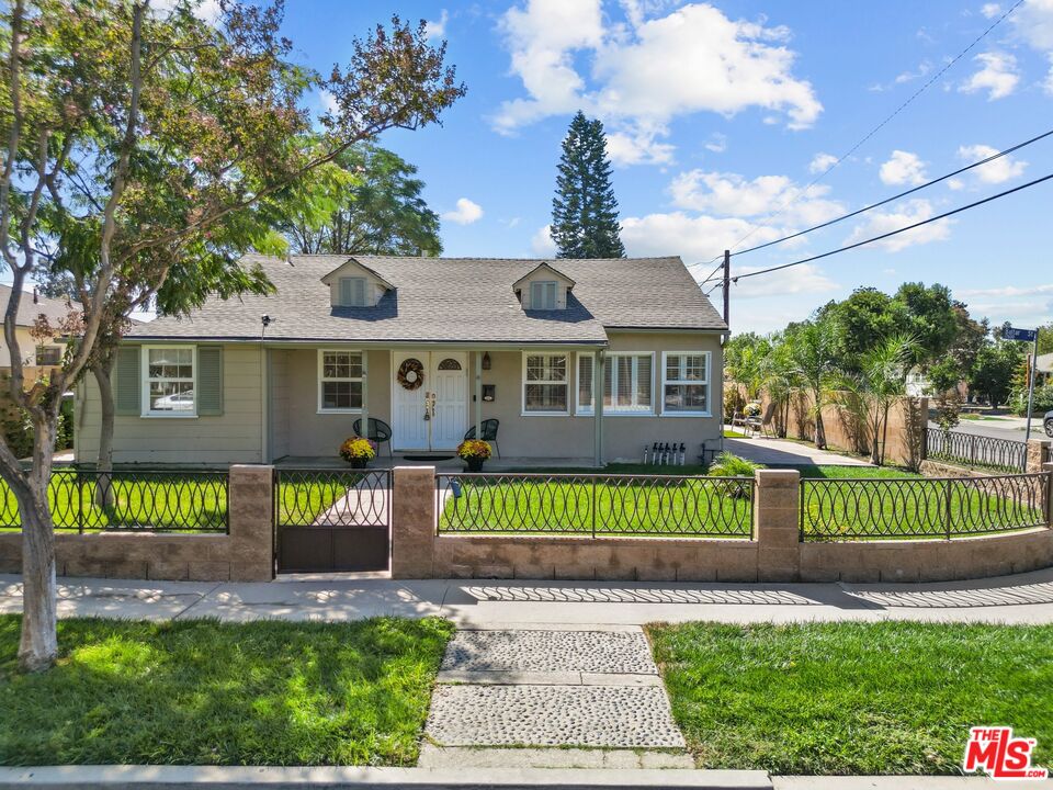 a front view of a house with a garden and plants