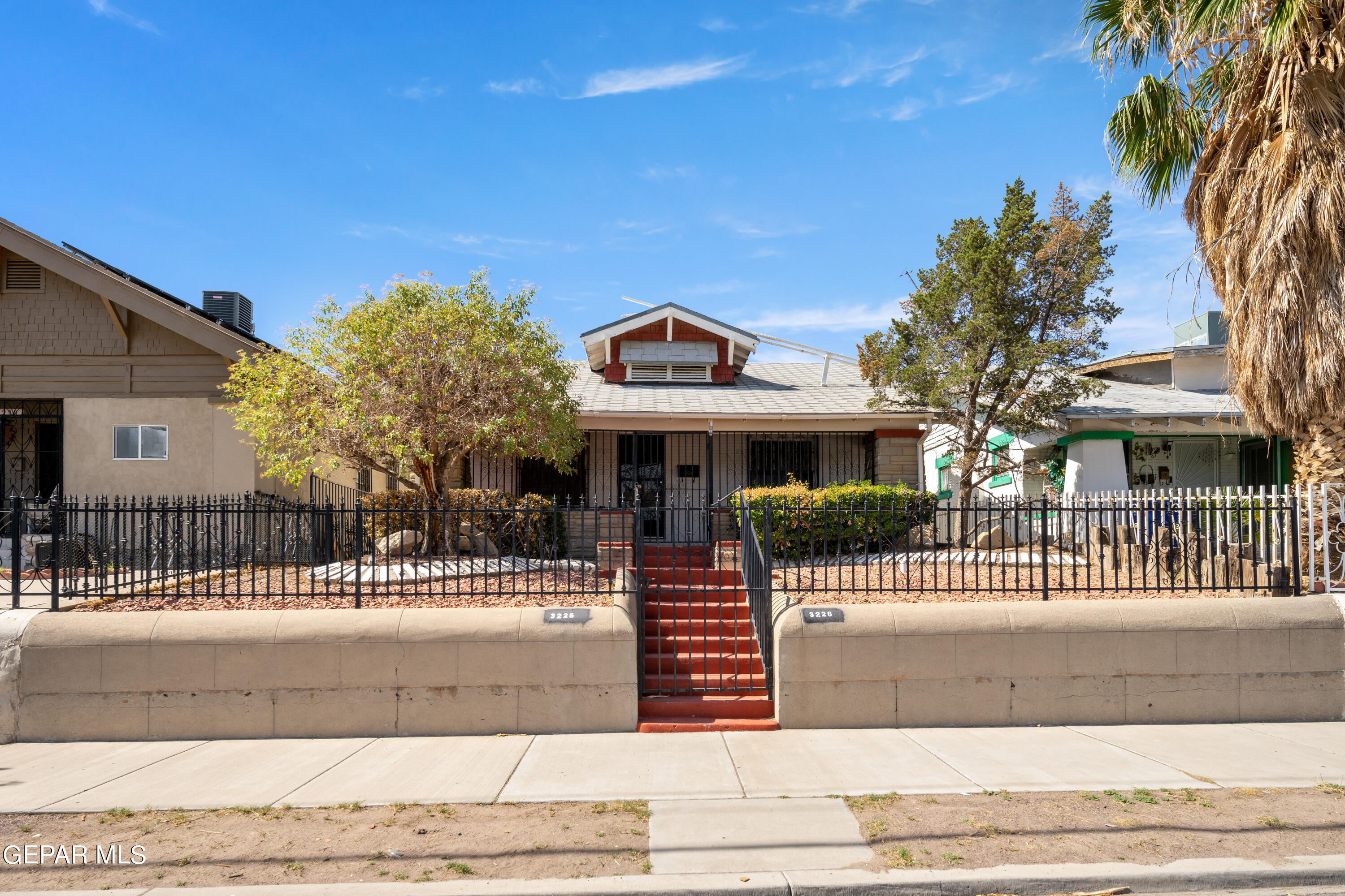 a front view of a house with a iron fence